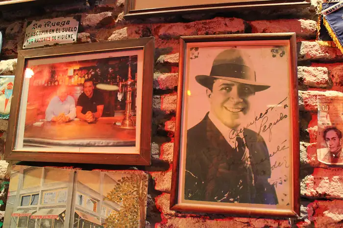 Pared de ladrillo con cuadros y fotos antiguas en Bar Fun Fun
